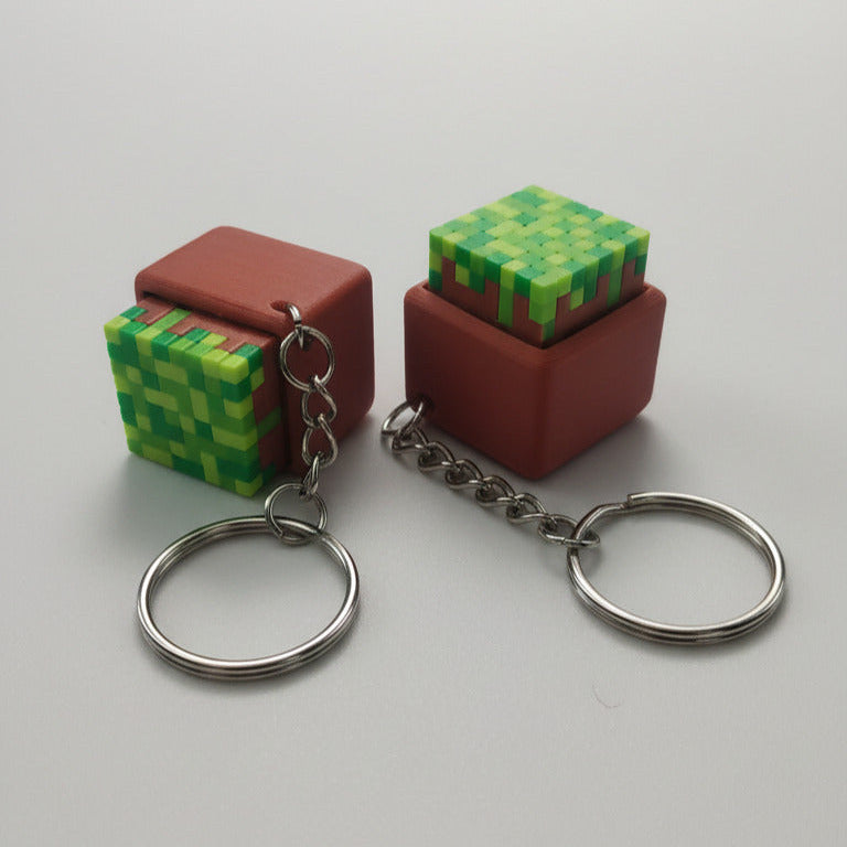Two pixelated cube keychains on a gray background