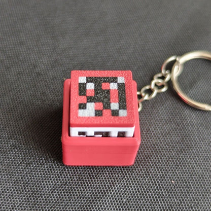 Pixelated keychain with red casing on a gray background