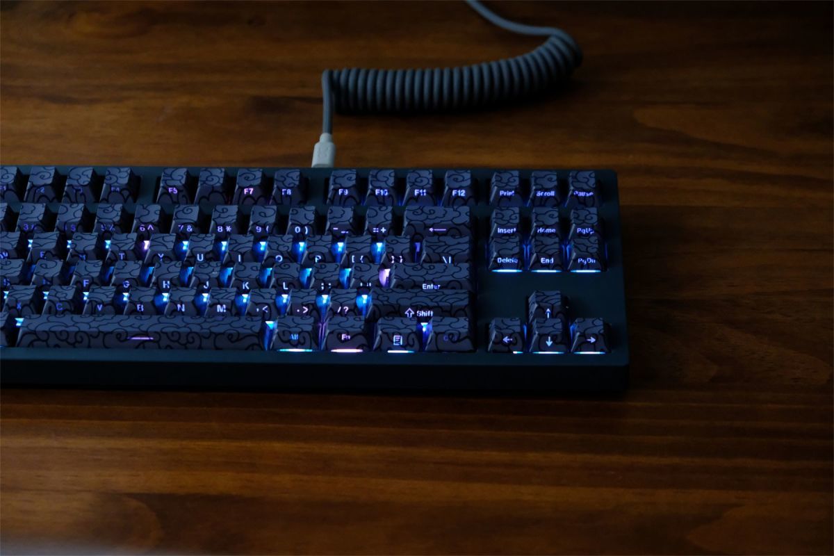 Mechanical keyboard with blue backlighting on a wooden surface