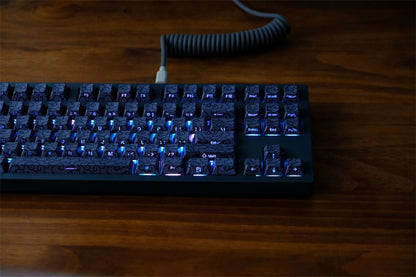 Mechanical keyboard with blue backlighting on a wooden surface